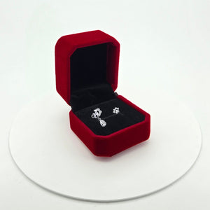 Cat & Paw Sterling Silver with Cubic Zirconia Asymmetrical Earrings  displayed inside an open red velvet jewellery box on a white circular platform against a white background.